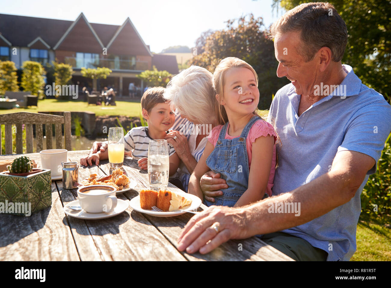 Großeltern mit Enkeln genießen Sie im Sommer einen Snack im Cafe Stockfoto