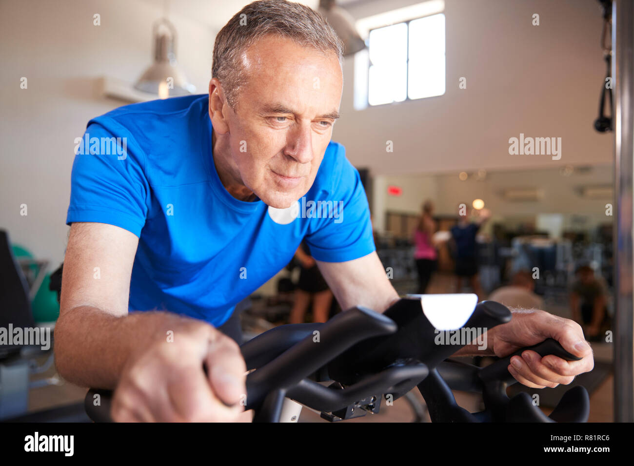 Älterer Mann Ausübung auf Radfahren Maschine In der Turnhalle Stockfoto