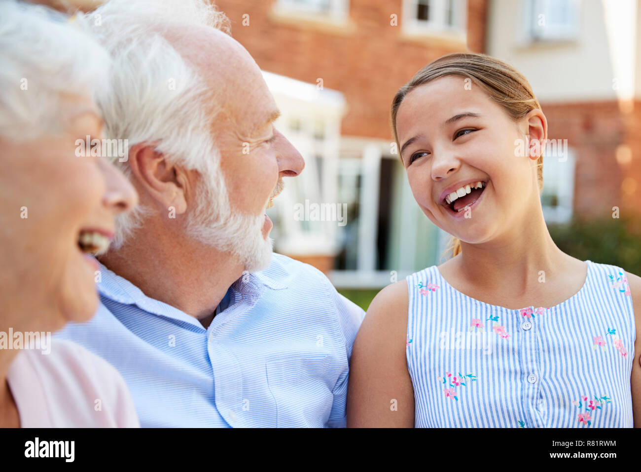 Enkelin im Gespräch mit den Großeltern während des Besuchs in den Ruhestand Home Stockfoto