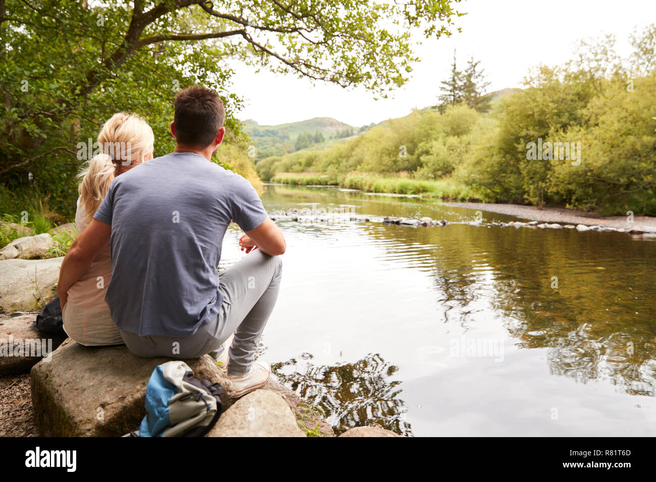 Paar auf Wanderung heraus über den Fluss in England Lake District suchen Stockfoto
