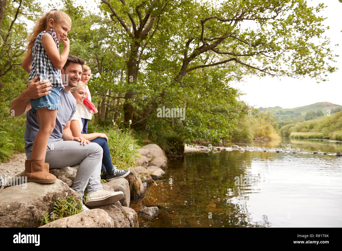 Familie auf Spaziergang mit Blick auf den Fluss in England Lake District Stockfoto