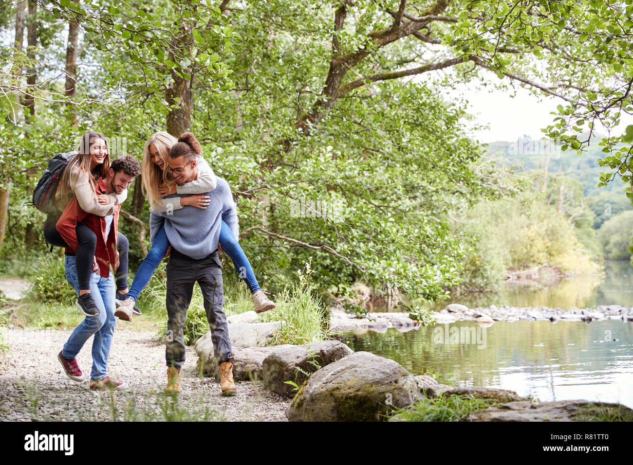 Vier erwachsene Freunde während einer Wanderung, Männer ihre Freundinnen Netzwerk zugreift. Stockfoto