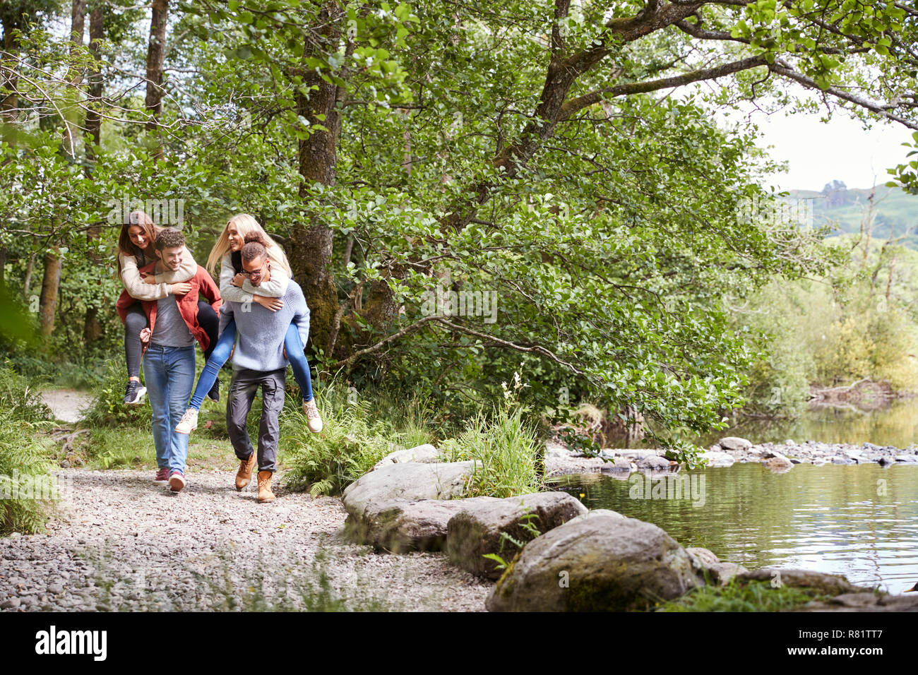 Vier junge erwachsene Freunde während einer Wanderung, Männer ihre Freundinnen Netzwerk zugreift. Stockfoto
