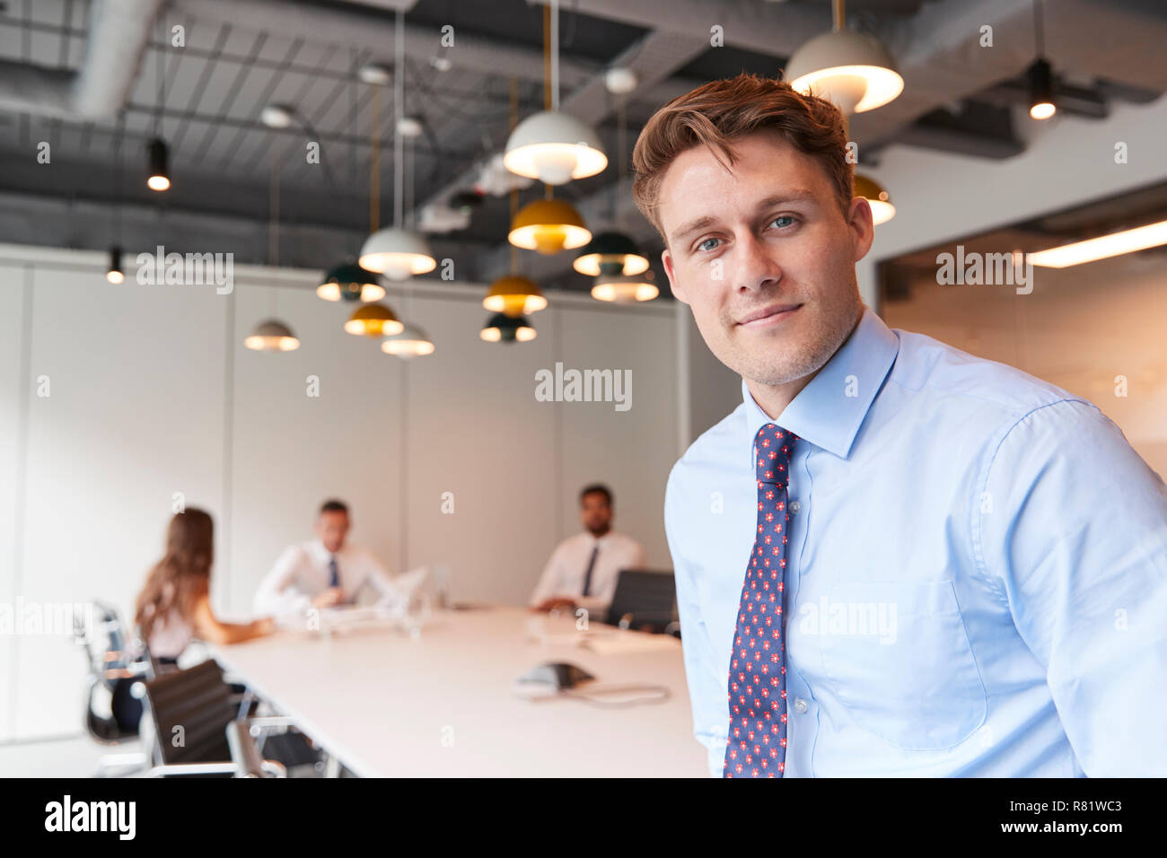 Portrait von Geschäftsmann in moderner Boardroom mit Kollegen treffen um den Tisch im Hintergrund Stockfoto