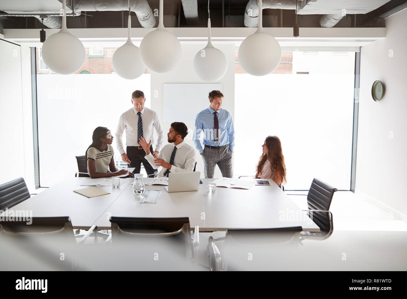 Unternehmer und Unternehmerinnen, um den Tisch in der modernen Sitzungssaal Stockfoto