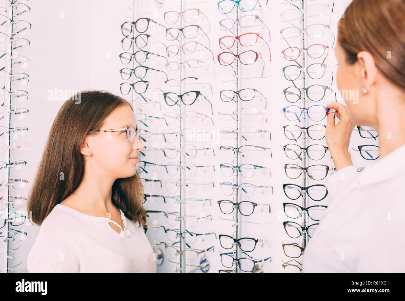 Junges Mädchen versucht, auf Brillen zum kleinen Optiker Stockfoto