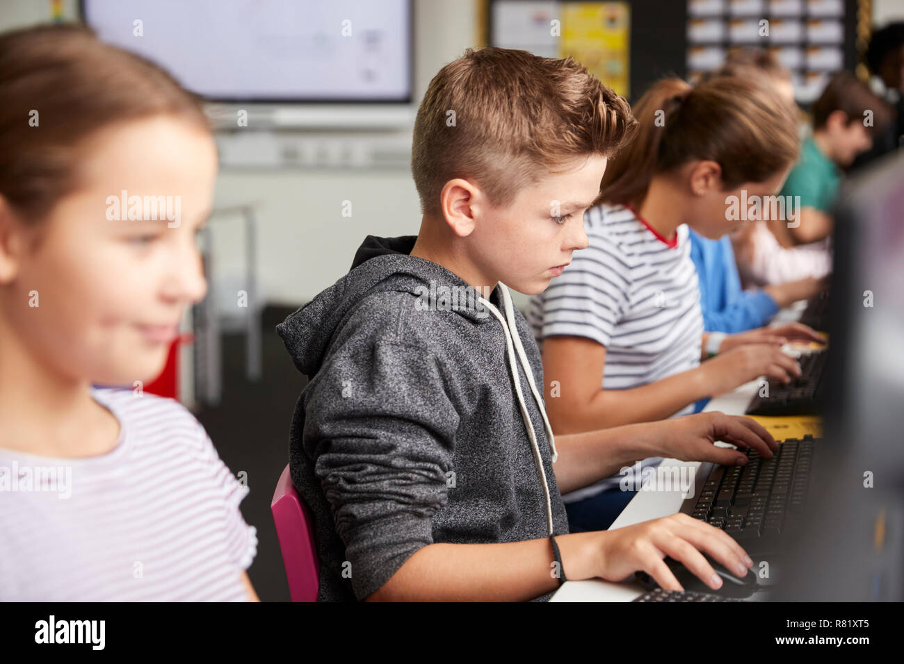 Linie der High School Kursteilnehmer an Bildschirmen arbeiten In Computer Klasse Stockfoto