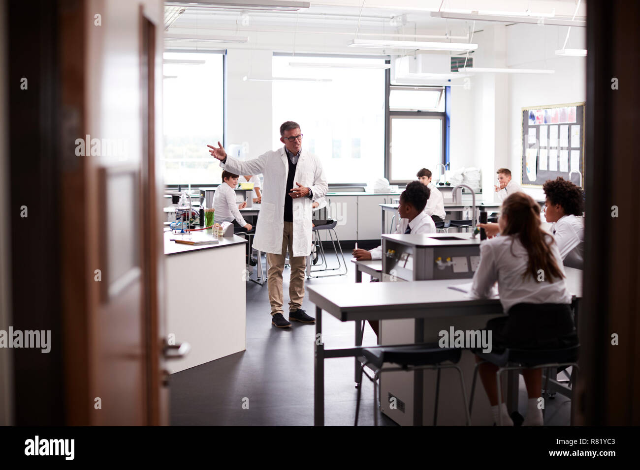 Männliche High School Lehrer Unterricht Schülerinnen und Schüler Schuluniformen tragen in Wissenschaft Kategorie Stockfoto