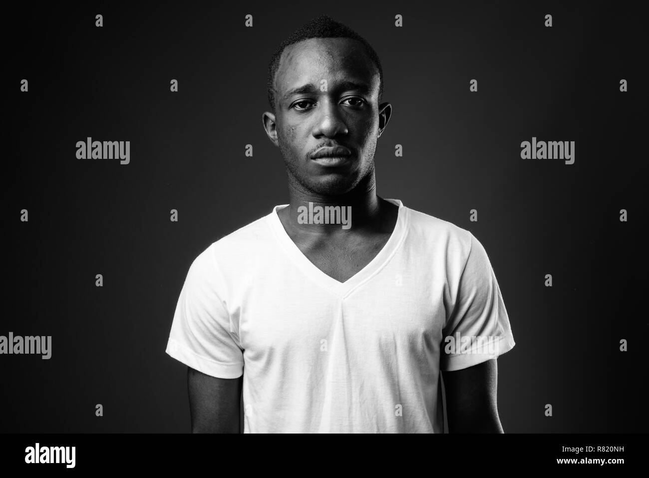Junge afrikanische Menschen gegen den schwarzen Hintergrund in Schwarz und Weiß Stockfoto