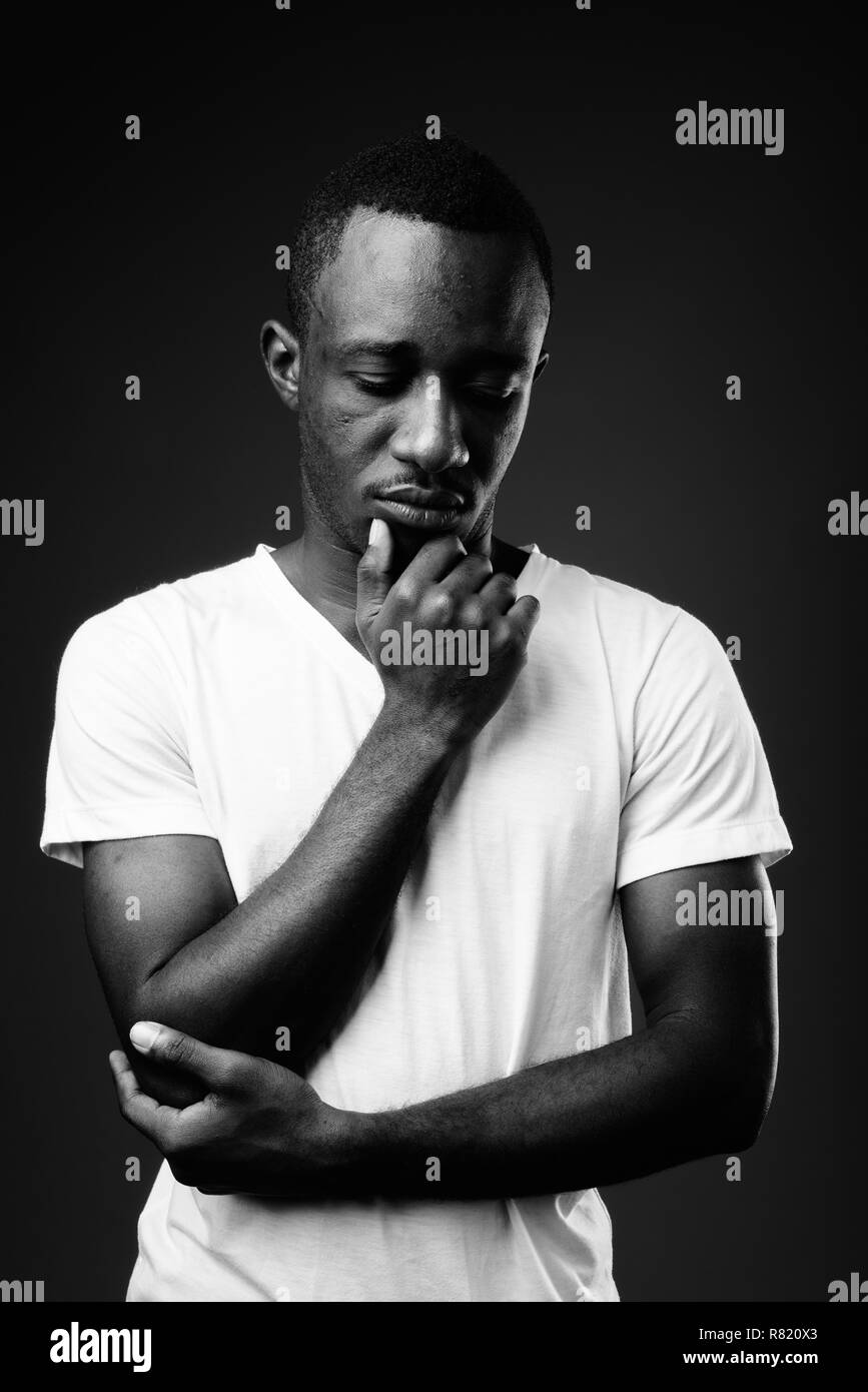 Junge afrikanische Mann gegen Denken in Schwarz und Weiß Stockfoto