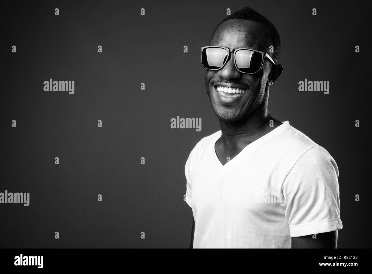 Junge afrikanische Mann Sonnenbrille tragen und lächelnd Stockfoto