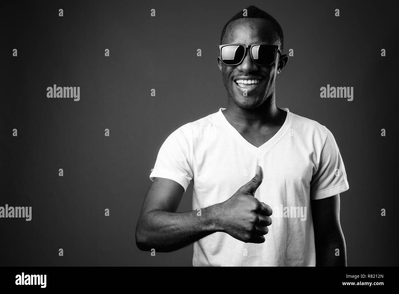 Junge afrikanische Mann Sonnenbrille tragen und Daumen hoch Stockfoto