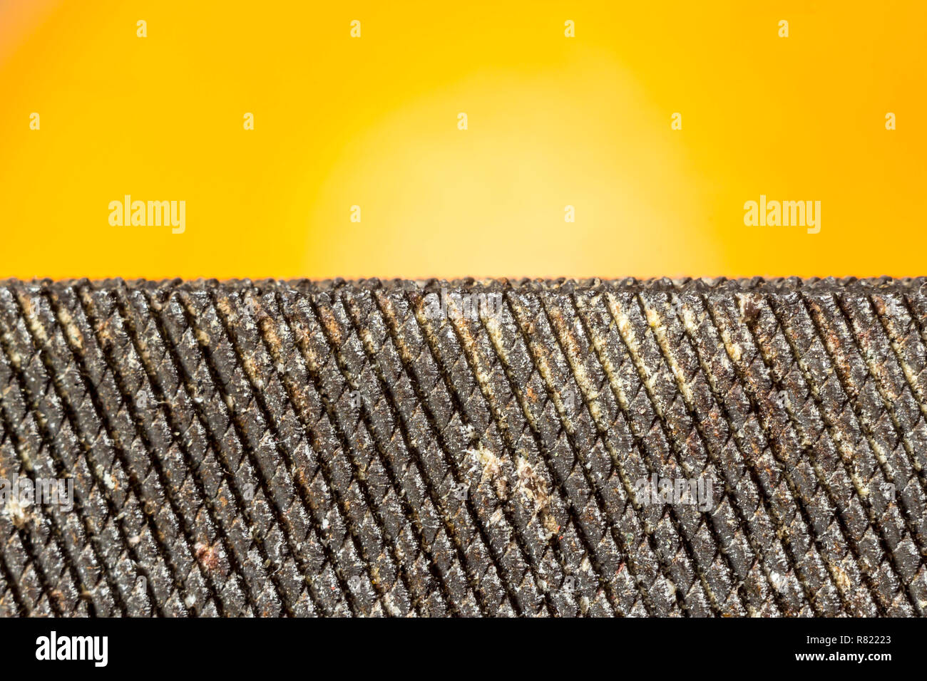 Metallwerkzeug hustet, close-up auf orangem Hintergrund. Mesh Metall oberfläche. Website über Werkzeuge, Metall, Metallverarbeitung. Stockfoto