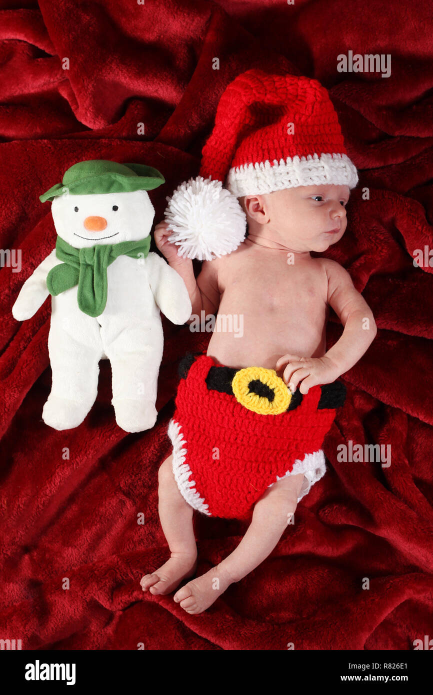 2 Wochen altes Baby Junge verkleidet als Weihnachtsmann mit Schneemann Stockfoto