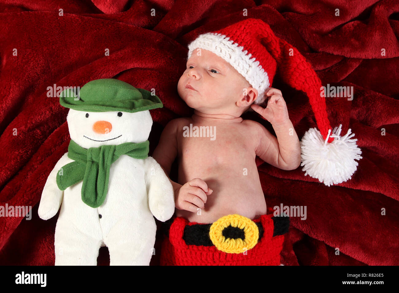 2 Wochen altes Baby Junge verkleidet als Weihnachtsmann mit Schneemann Stockfoto
