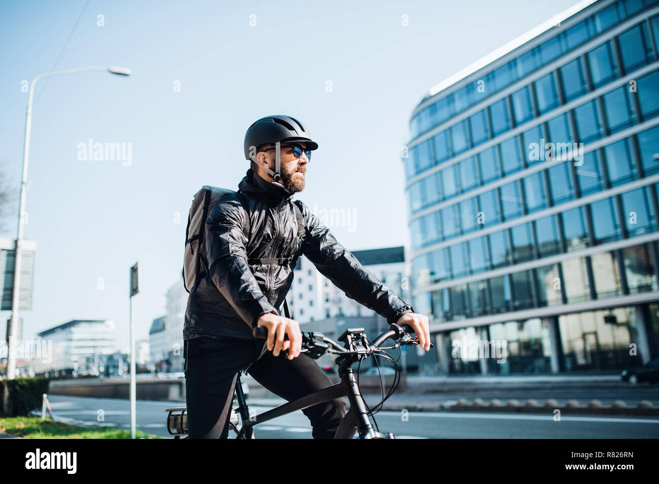 Männliche Kurier mit dem Fahrrad die Auslieferung von Paketen in der Stadt. Kopieren Sie Platz. Stockfoto