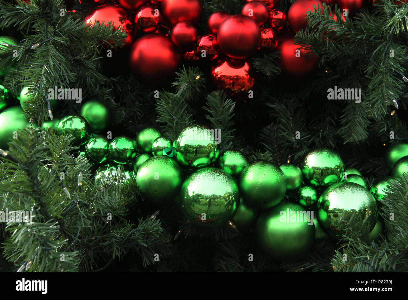 Rot und Grün Weihnachtsverzierungen in großen künstlichen Baum Stockfoto