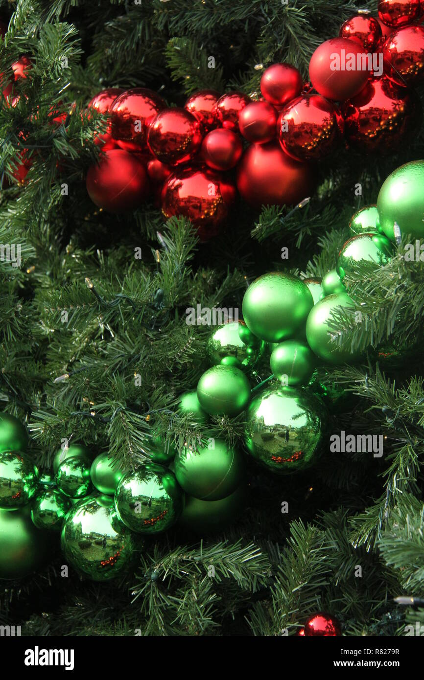 Rot und Grün Weihnachtsverzierungen in großen künstlichen Baum Stockfoto