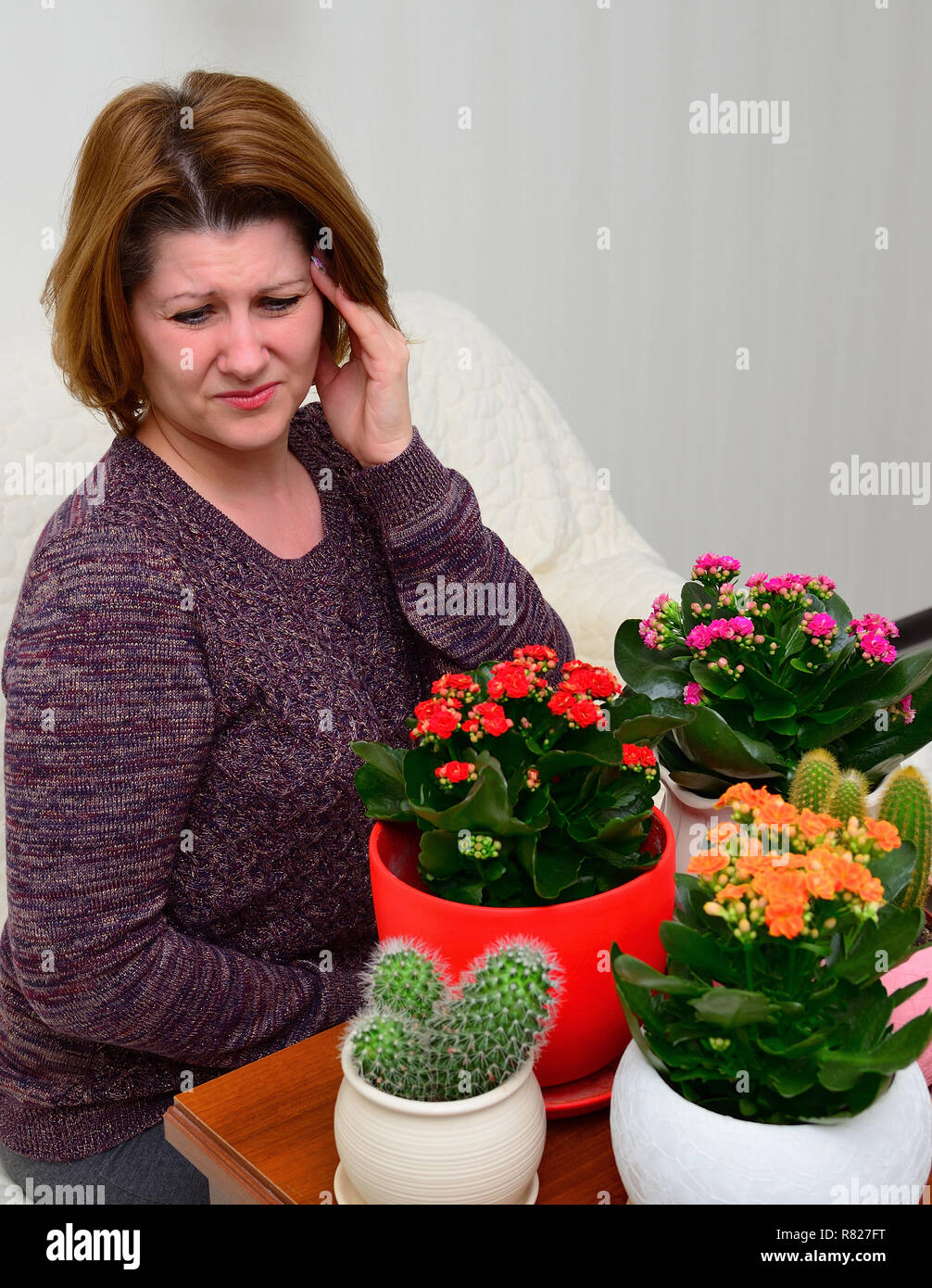 Frau mit Kopfschmerzen in der Nähe der Pflanzen Stockfoto