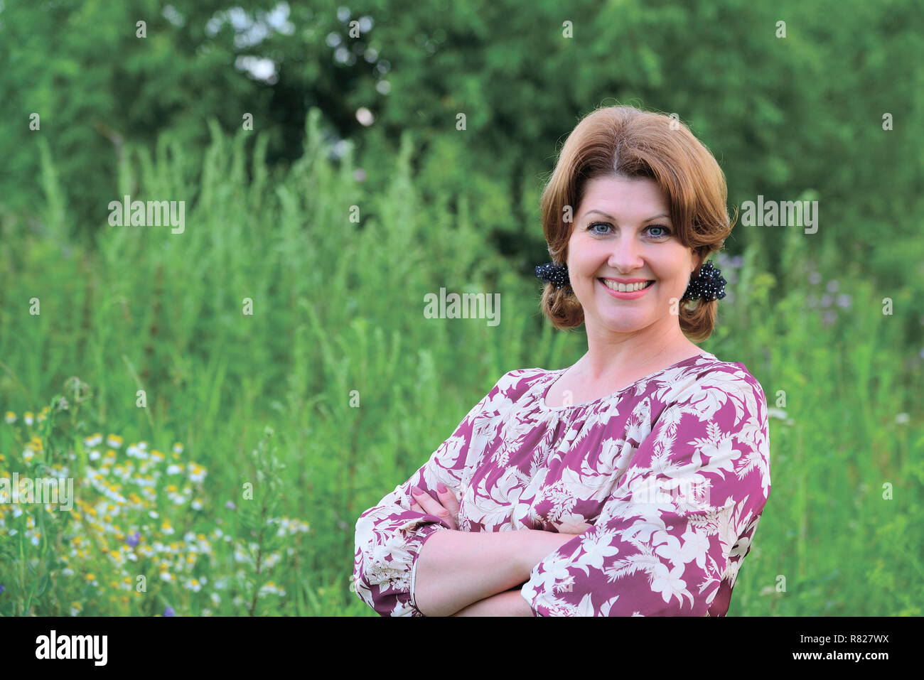 Porträt der schönen Frau, die auf dem Hintergrund der hohen Gras Stockfoto