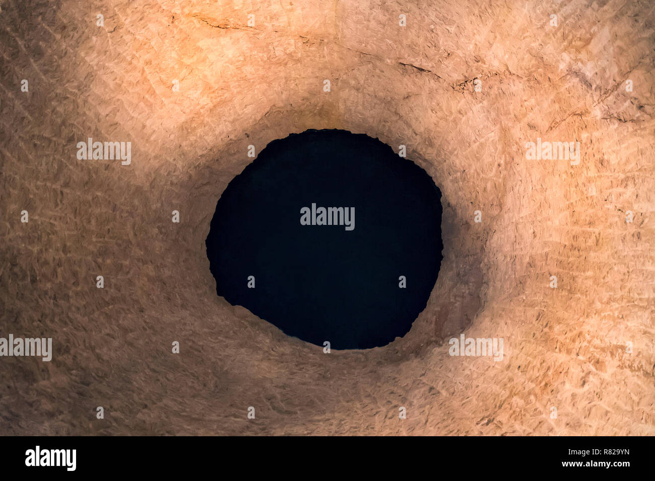 Ein schwarzes Loch in einer Felsspalte. Abstraktion Stockfoto