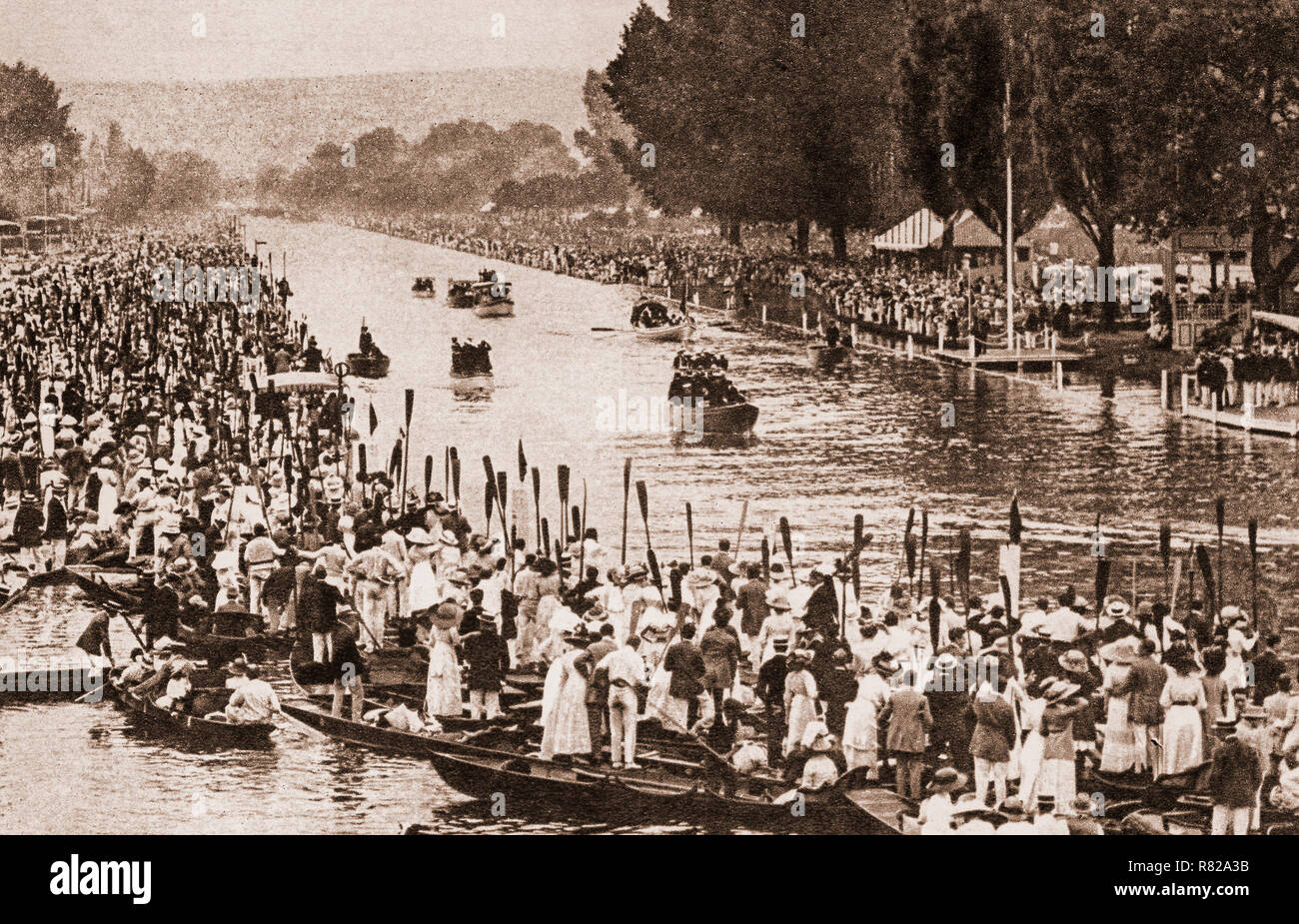 Rudern in Salute angehoben als die Königlichen Barkasse Lager King George V und die Königliche Familie seinen Weg macht auf der Regattabahn am 6. Juli 1912 in Henley-on-Thames, einer Stadt an der Themse in Oxfordshire, England. Es war das einzige Mal, dass der König Henley Royal Regatta, obwohl es wurde 'Royal' im Jahr 1851, als Prinz Albert Gönner der Regatta wurde. Stockfoto
