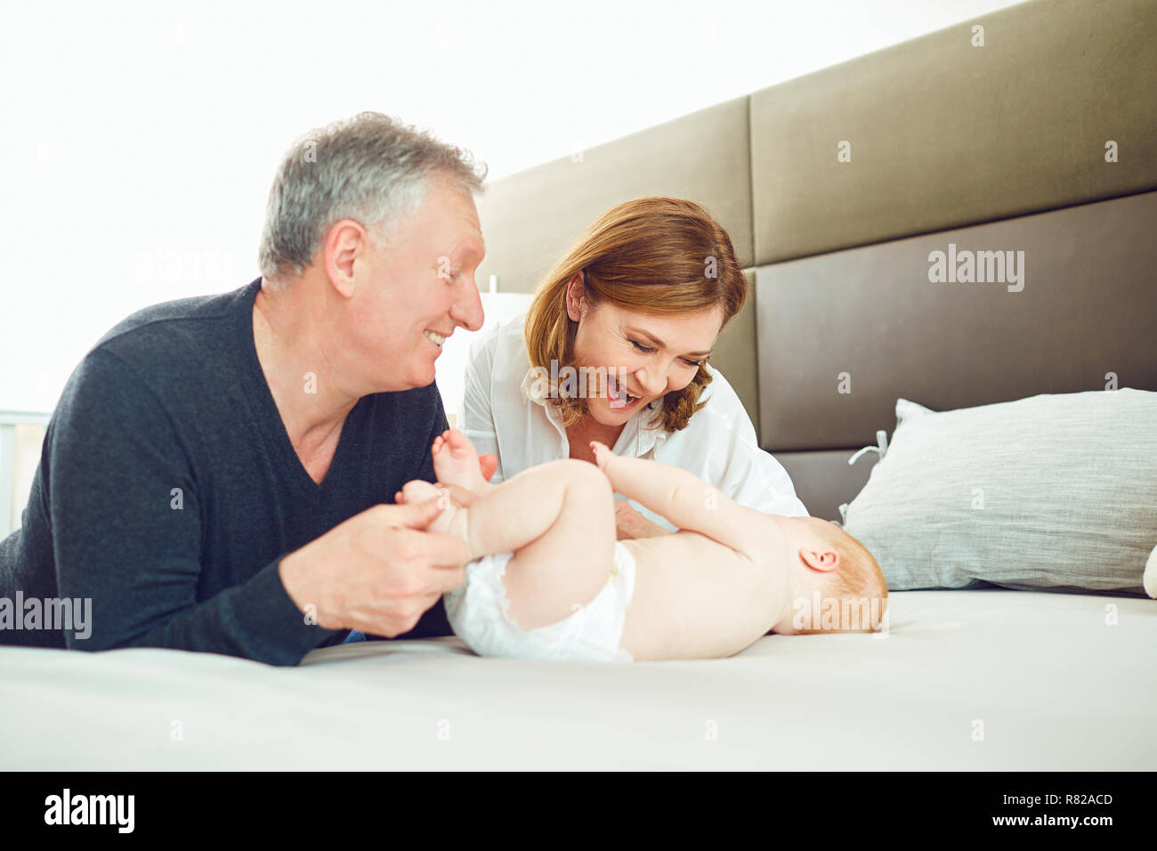 Großeltern und das Baby Spielen auf dem Bett. Stockfoto