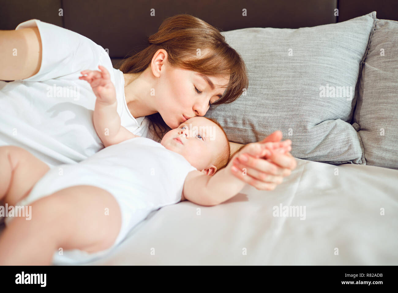 Mutter spielt mit Baby auf dem Bett. Stockfoto