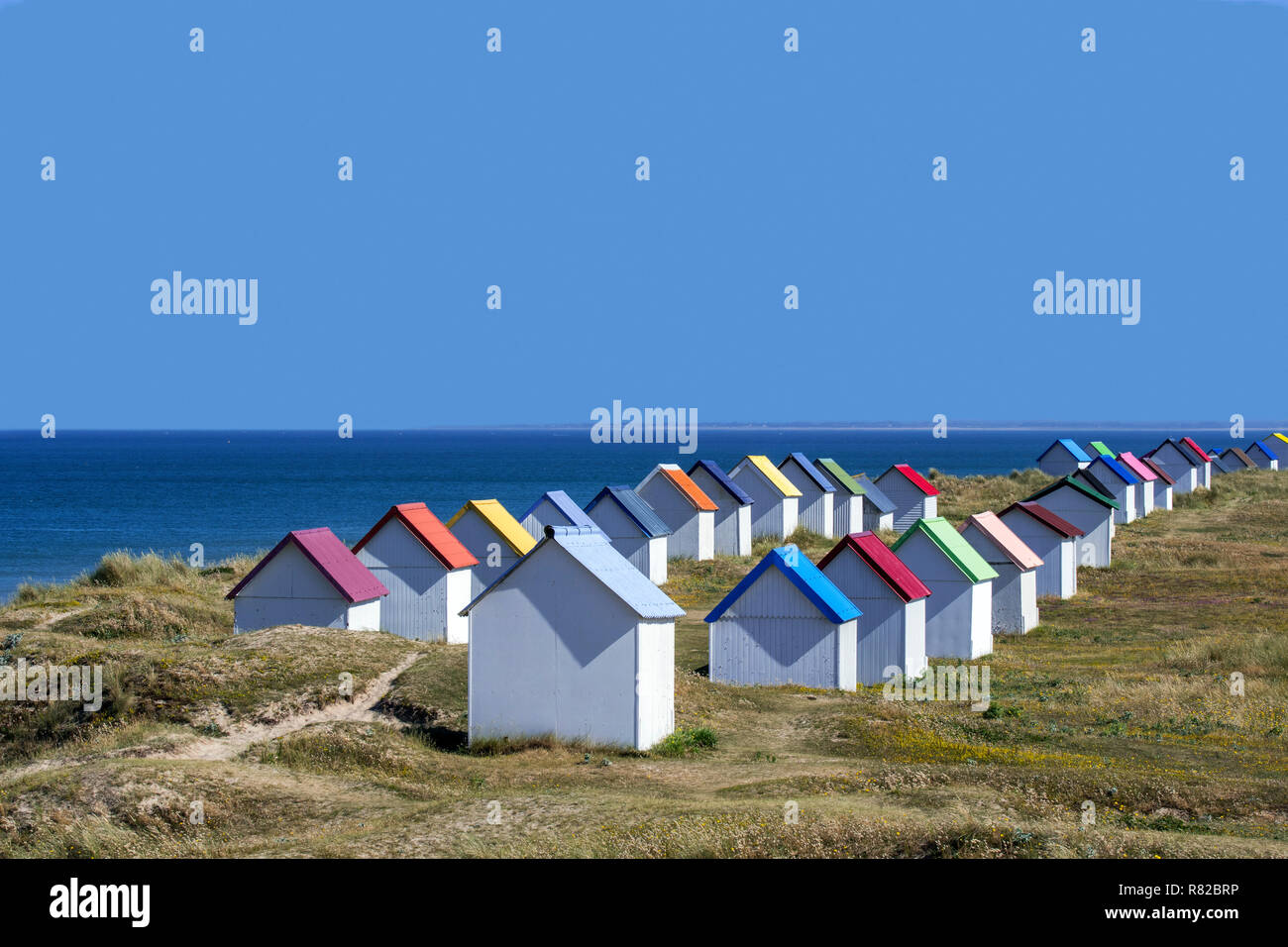 Reihe von bunten Beach Cabins in den Dünen bei Gouville-sur-Mer, Languedoc-Roussillon, Frankreich Stockfoto