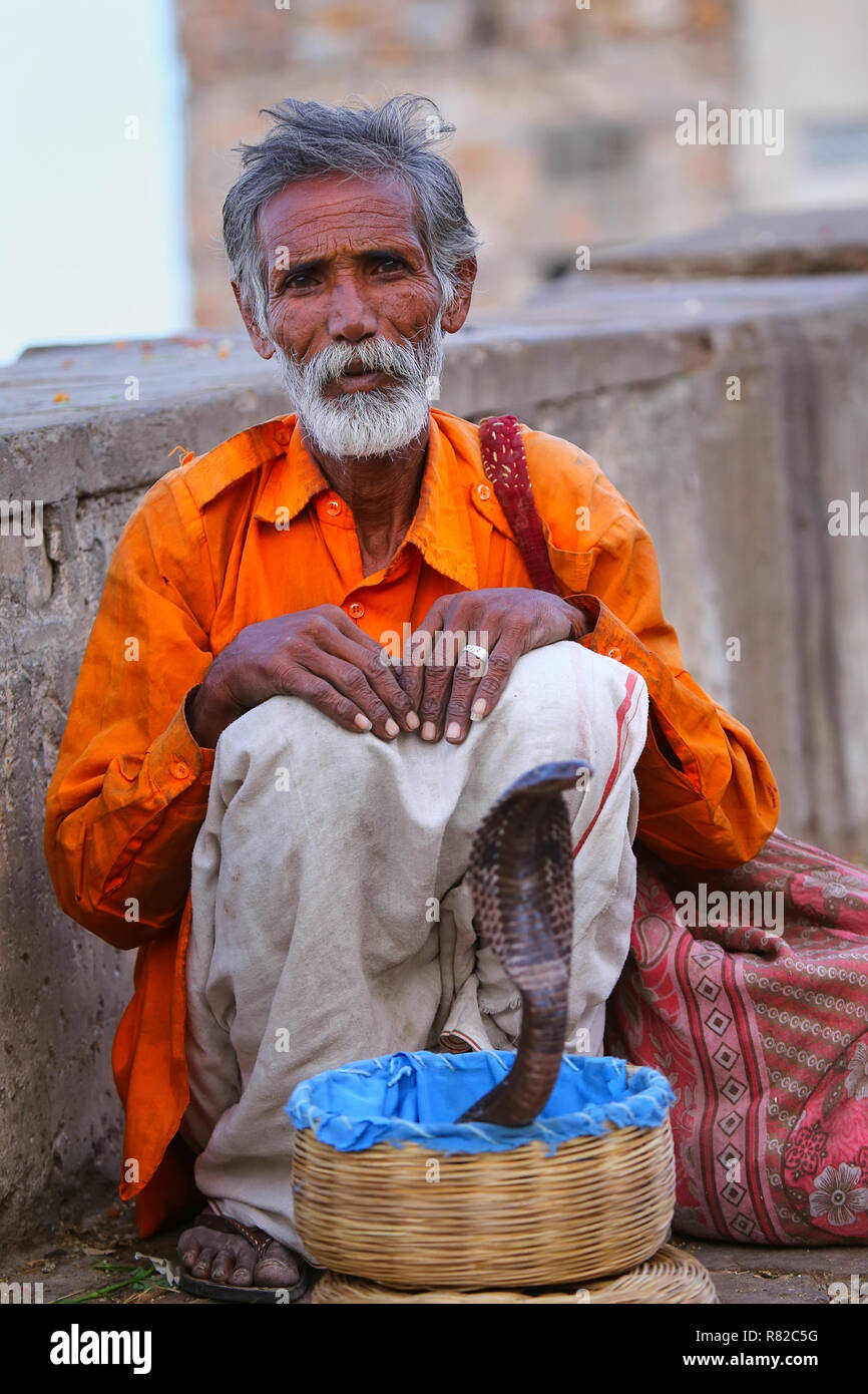 Lokalen Schlangenbeschwörer sitzen auf der Straße von Jaipur, Indien. Jaipur ist die Hauptstadt und größte Stadt im indischen Bundesstaat Rajasthan. Stockfoto