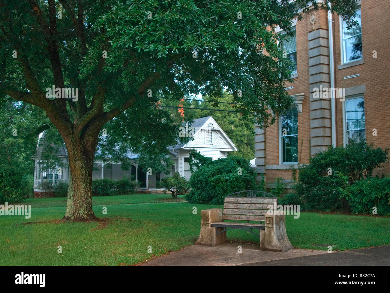 Eine hölzerne Bank bietet einen schattigen Platz im Hale County Courthouse in Greensboro, Alabama zu entspannen. Stockfoto