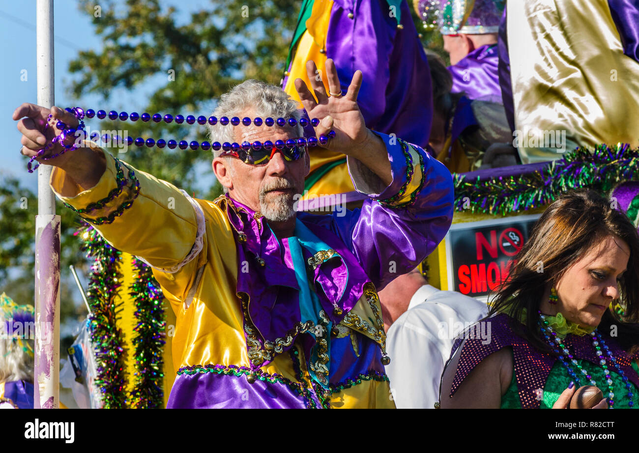 Ein Mitglied der Kain Raiser Gesellschaft taunts Parade goers mit einer Perlenkette während der JOW Kain Day Parade am Mardi Gras in Mobile, Alabama. Stockfoto