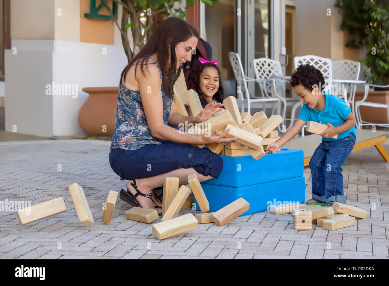 Die Vermischung Turm fällt auseinander, während jeder Lachen ist und versucht, Sie von überall auf der Terrasse zu halten. Mom-Ausgaben. Stockfoto