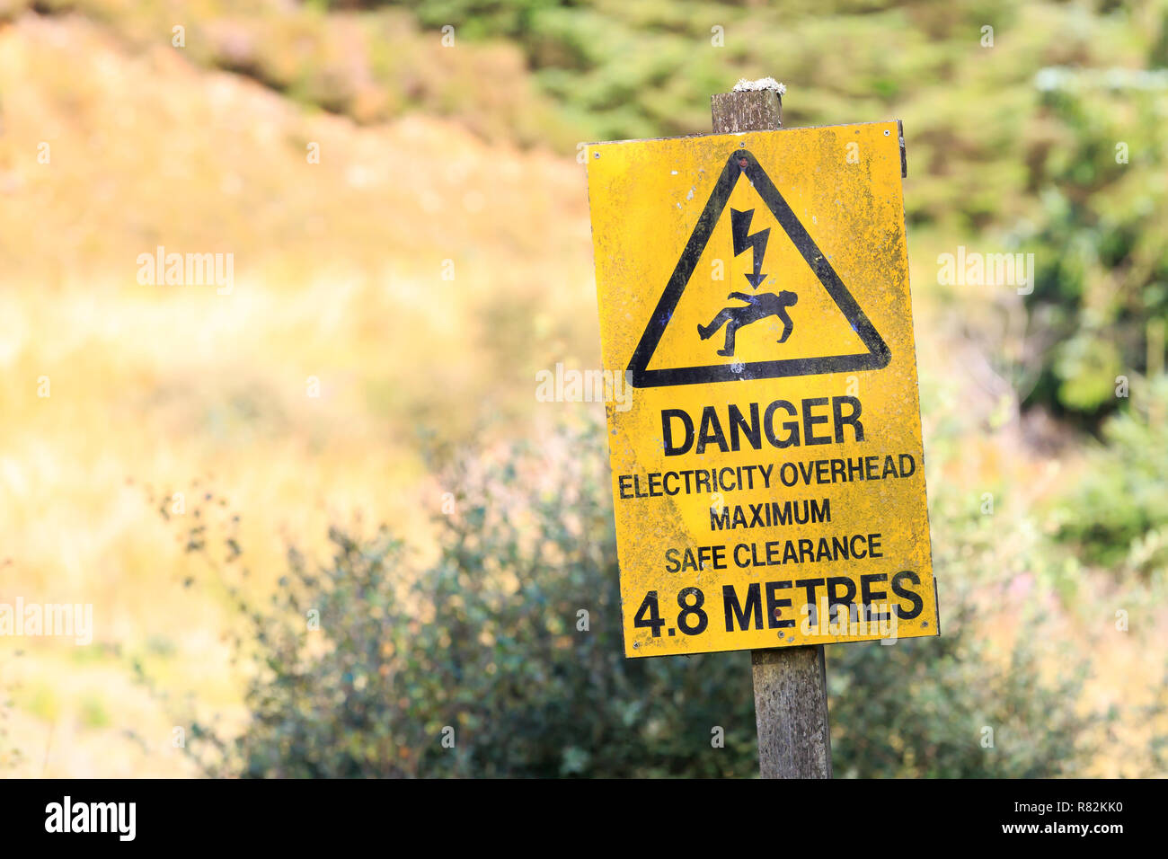 Gelbes schild Warnung vor Gefahr strom Overhead Stockfoto