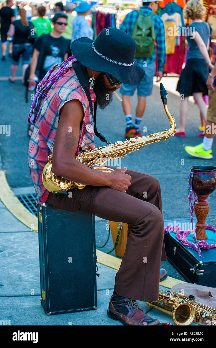 Portland, Oregon, USA - August 17,2014: Hawthorn Street der jährliche Veranstaltung. Ein strassenmusiker nimmt einen Bruch von seinem Saxophon spielen. Stockfoto