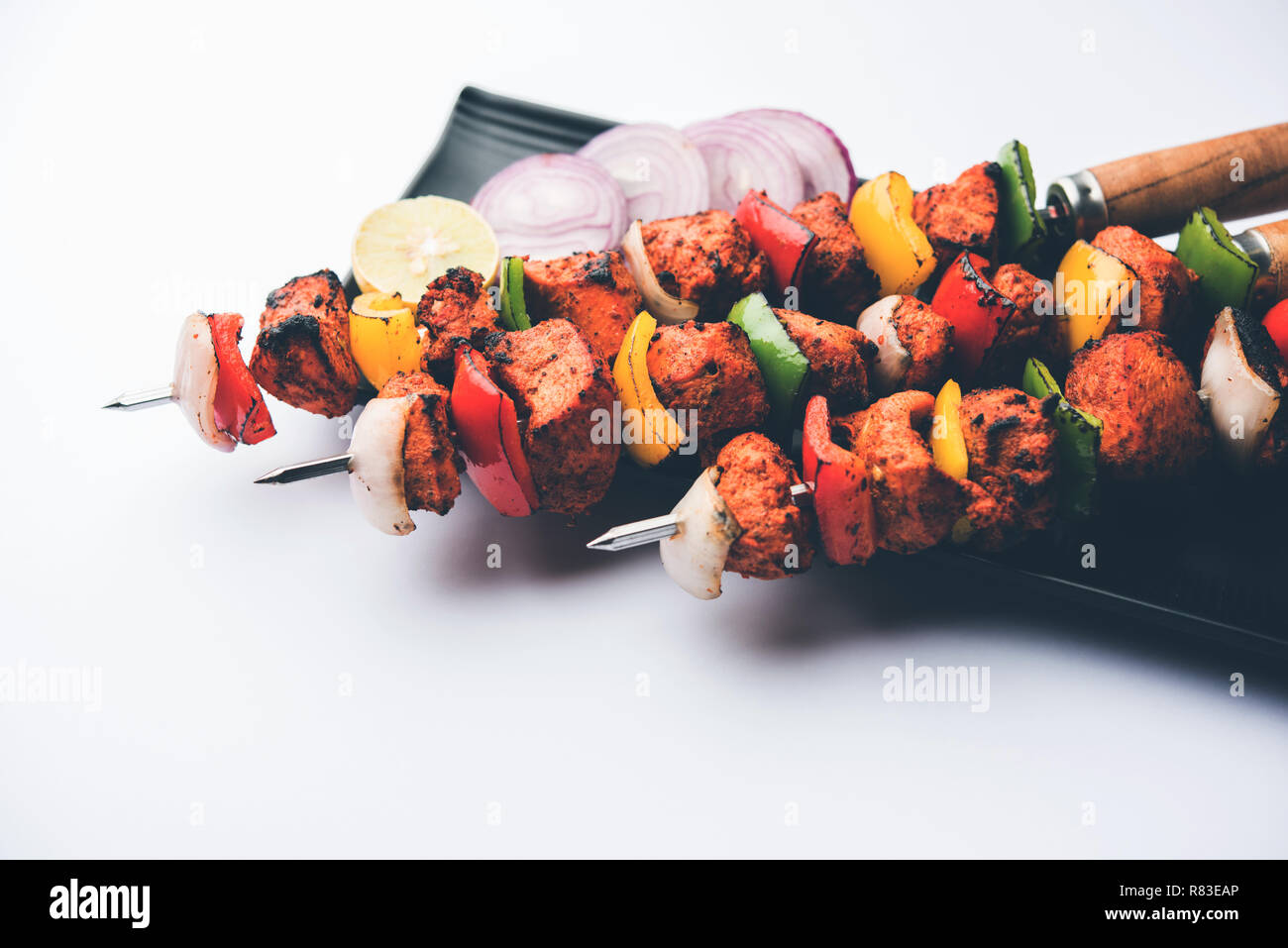 Chicken Tikka/skew Kebab. Traditionelle indische Gericht gekocht auf Holzkohle und Flamme, gewürzt & bunt garniert. Mit grüner Chutney und Salat serviert. Stockfoto