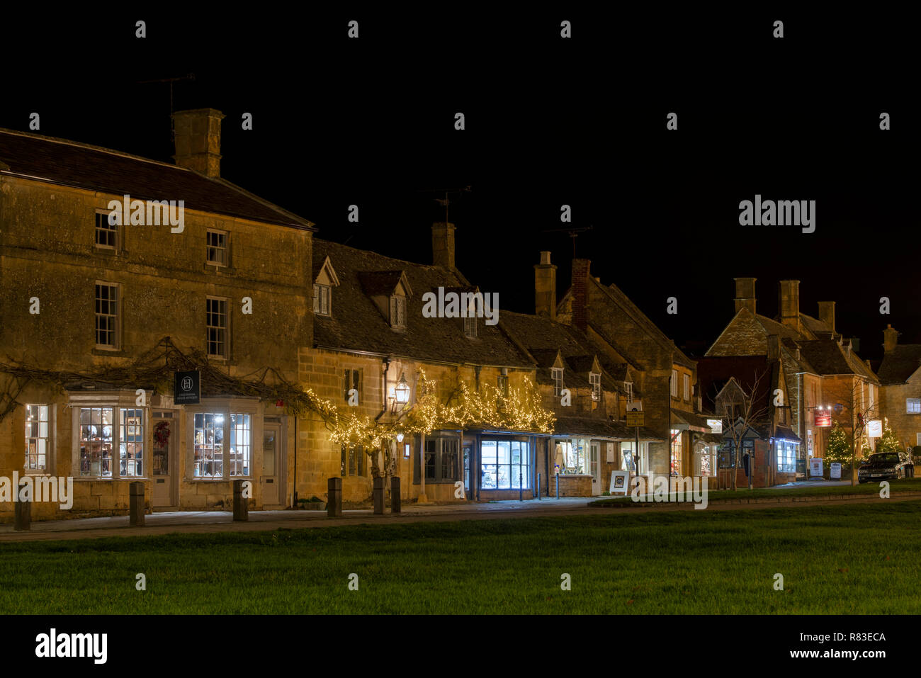 Broadway Geschäfte auf der Hauptstraße im dezember in der Nacht. Broadway, Cotswolds, Worcestershire, England Stockfoto