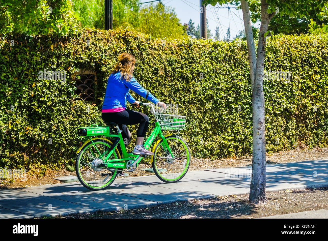 August 26, 2018 Mountain View/CA/USA - Mädchen reiten ein Kalk Fahrrad auf einem Bürgersteig in Silicon Valley; Kalk ist eine US-amerikanische Transport firma Stockfoto