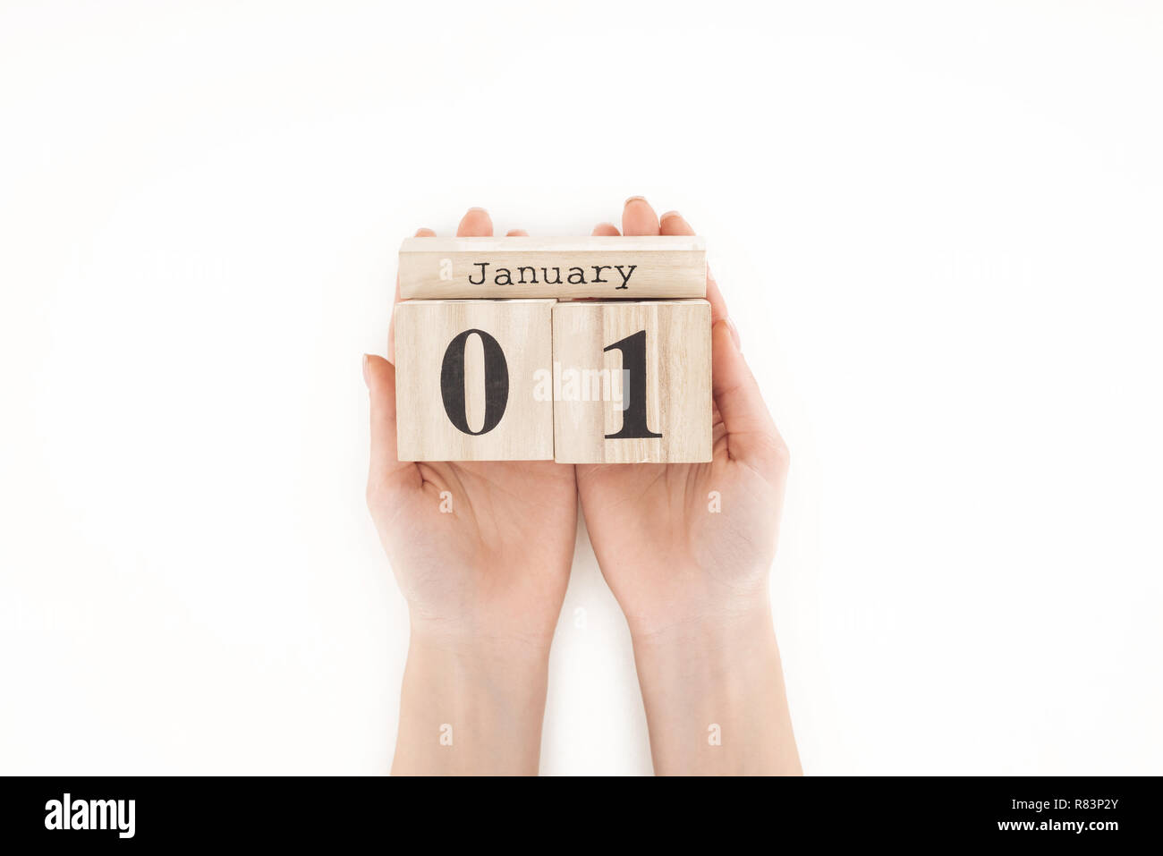 Teilweise mit Blick auf die Frau mit Holzwürfeln mit 1. Januar Datum isoliert auf weißem Stockfoto