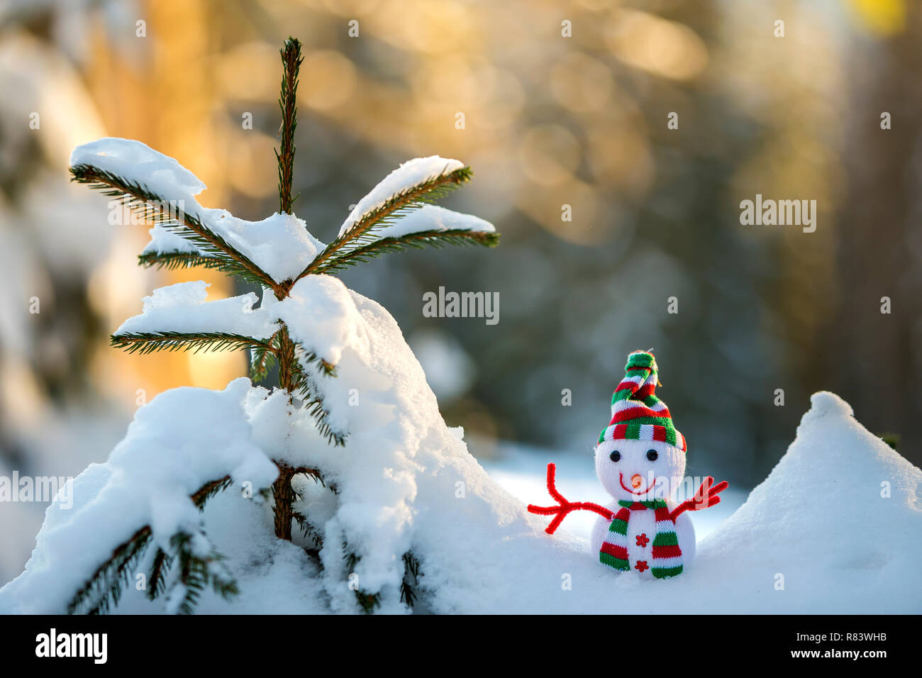 Kleine lustige Spielzeug baby Schneemann auf gestrickte Mütze und Schal in  tiefem Schnee draussen auf helle blaue und weiße Kopie Raum Hintergrund.  Frohes Neues Jahr und Frohe C Stockfotografie - Alamy