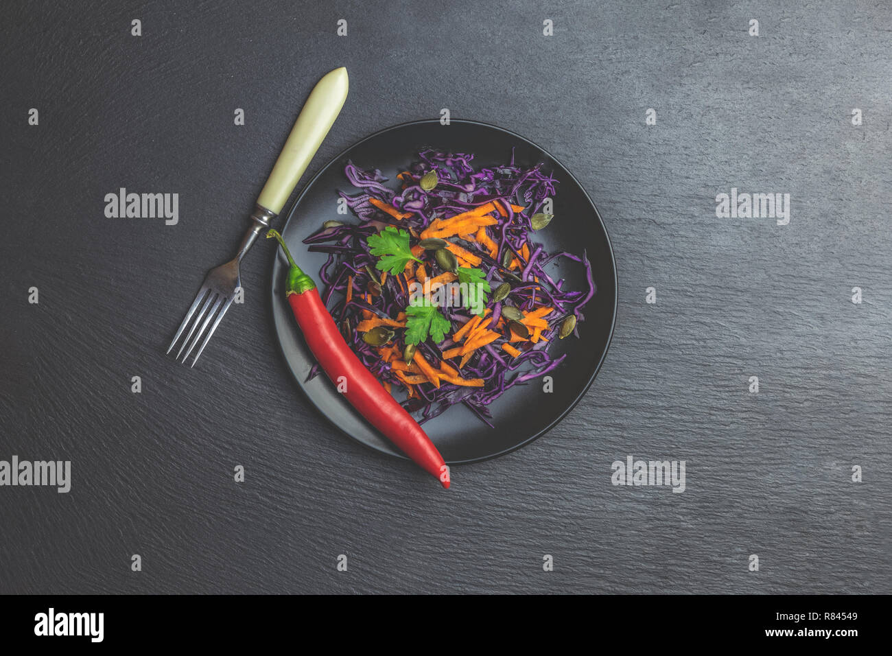 Salat Von Lila Kohl Karotten Kurbis Samen Petersilie Und Chili In Schwarz Keramikplatte Auf Schwarzem Stein Oberflache Ansicht Von Oben Kopieren Gewurz Stockfotografie Alamy
