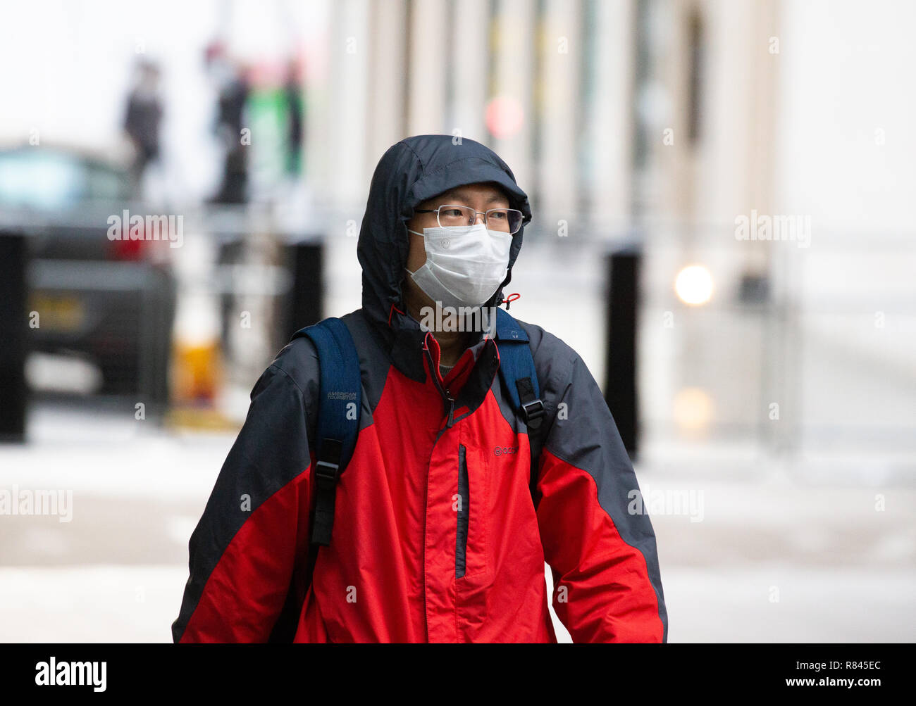 Ein japanischer Tourist in London das Tragen einer Luftverschmutzung Gesichtsmaske die Giftstoffe und Verschmutzungen in der Luft zu bekämpfen Stockfoto