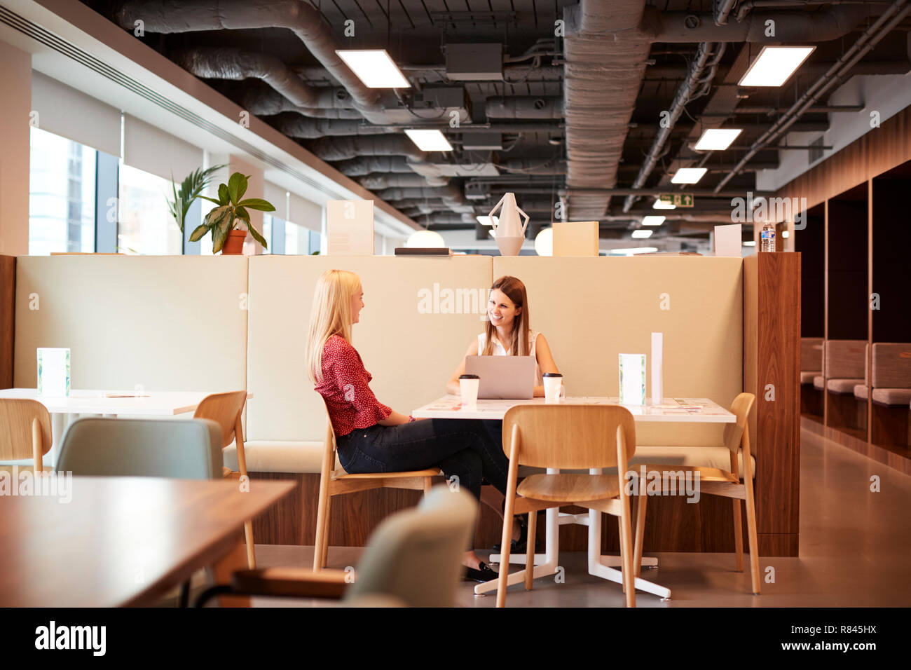 Zwei junge Unternehmerinnen in informellen Interview in der Cafeteria der Graduate Recruitment Assessment Day Stockfoto
