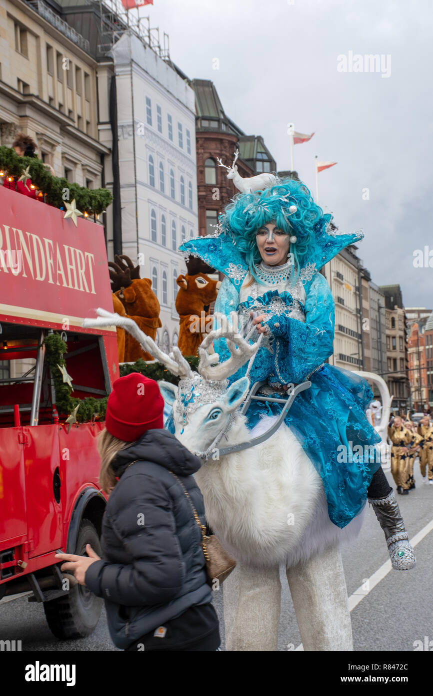 Hamburg Deutschland - vom 8. Dezember 2018: Junge Frau in Hamburg Christmas Parade reiten Marionette Schleichen oben auf Benutzer von Mobiltelefonen Stockfoto