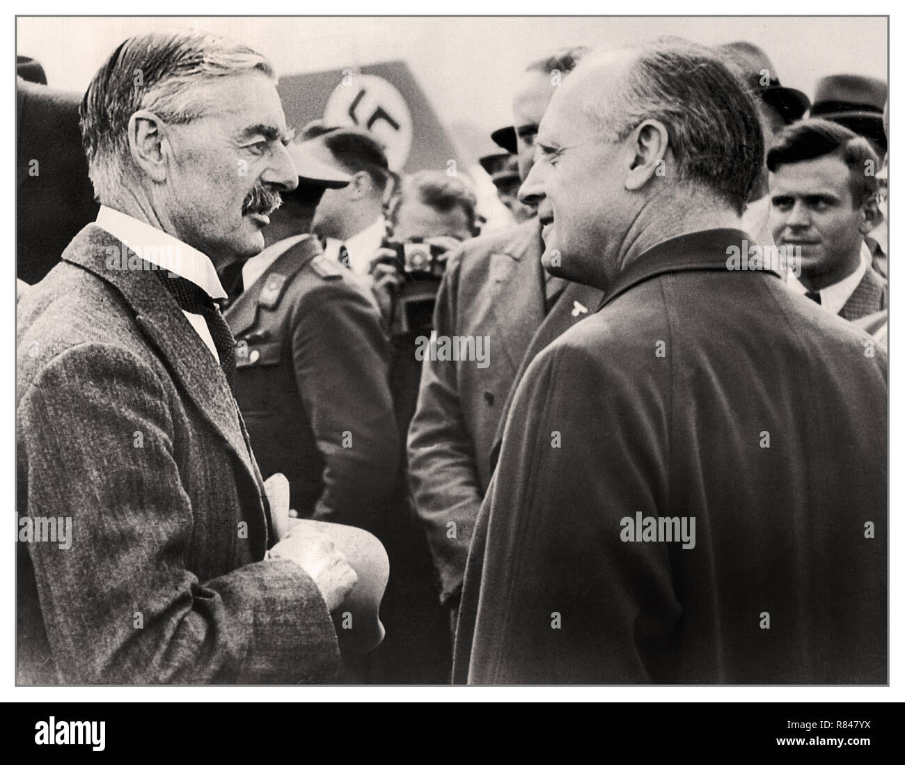 CHAMBERLAIN 1938 der britische Premierminister Neville Chamberlain Chats mit deutschen Außenminister Joachim von Ribbentrop bei seiner Ankunft am Flughafen München, Deutschland Sept. 15, 1938 "Frieden in unserer Zeit" Premierminister Neville Chamberlain hatte angeblich Europa mit dem Münchner Abkommen gerettet, so dass Hitler zu Anhang das Sudetenland, aber die Öffentlichkeit fand das Stück Papier, das er nach seiner Rückkehr nach Großbritannien fast wertlos zu sein, winkte... Stockfoto
