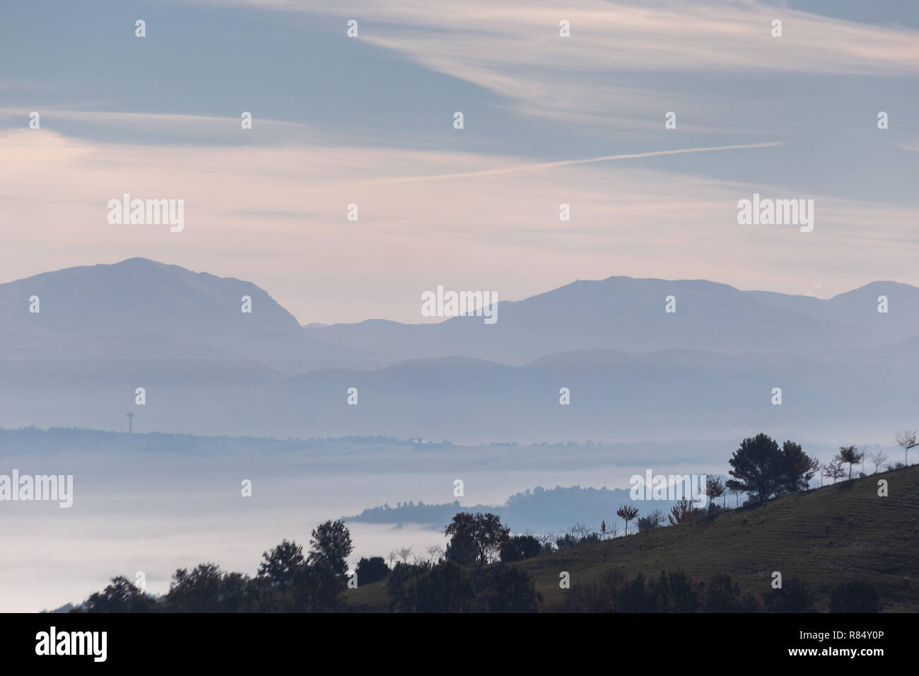 Nebel füllen ein Tal in Umbrien (Italien), die mit den Schichten der Berge und Hügel und verschiedenen Blautönen. Stockfoto