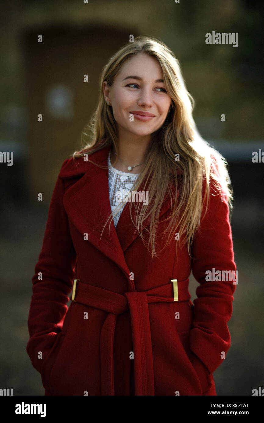 Junge Frau zu Fuß das Tragen der roten Mantel Stockfoto