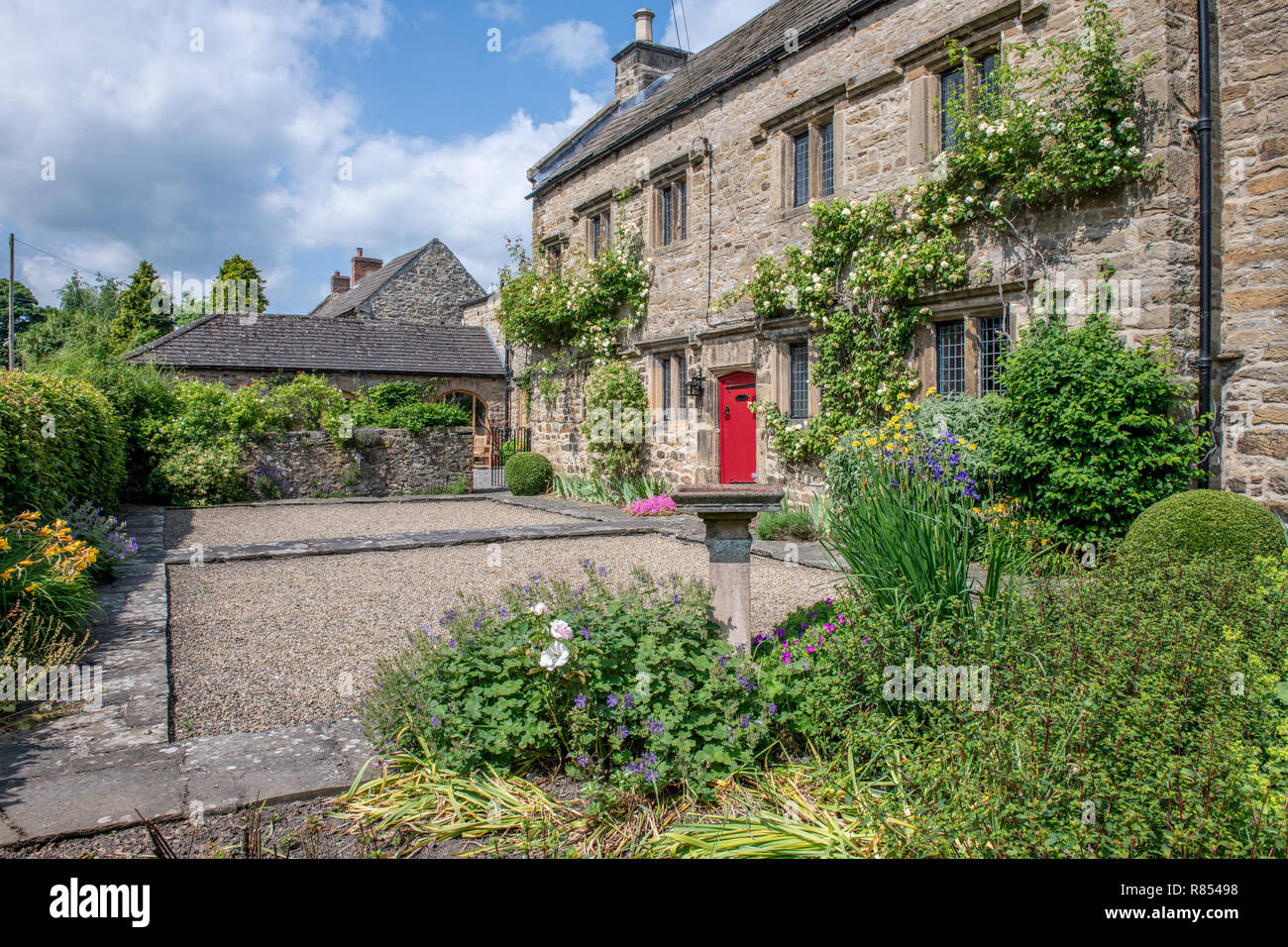 Eine helle rote Tür markiert den Eingang zu Halle Kiplin, Richmond, Yorkshire, Großbritannien Stockfoto