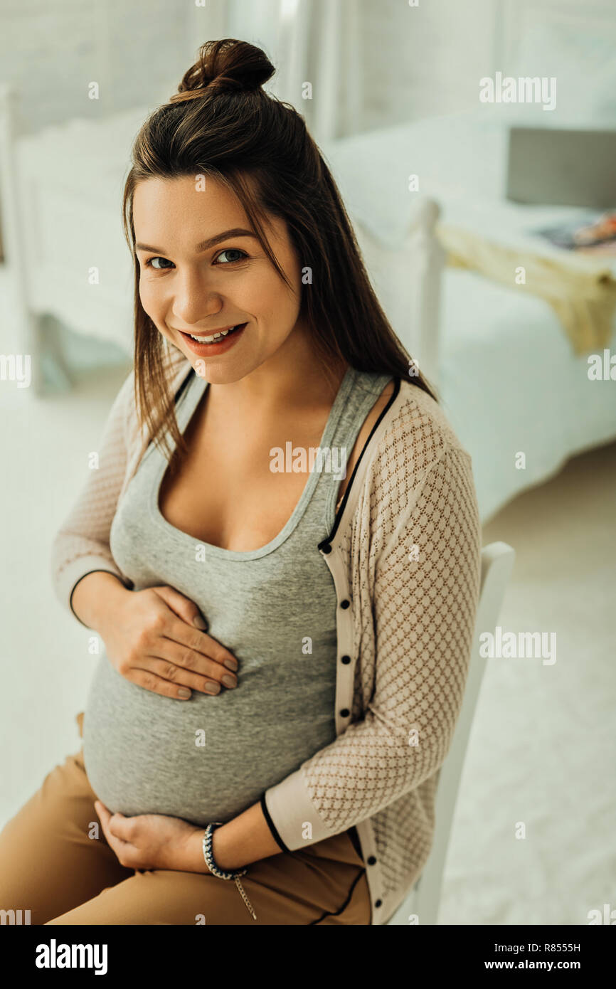 Zu einer Mutter. Ein glücklich aussehende Frau ihrer schwangeren Bauch berühren. Stockfoto