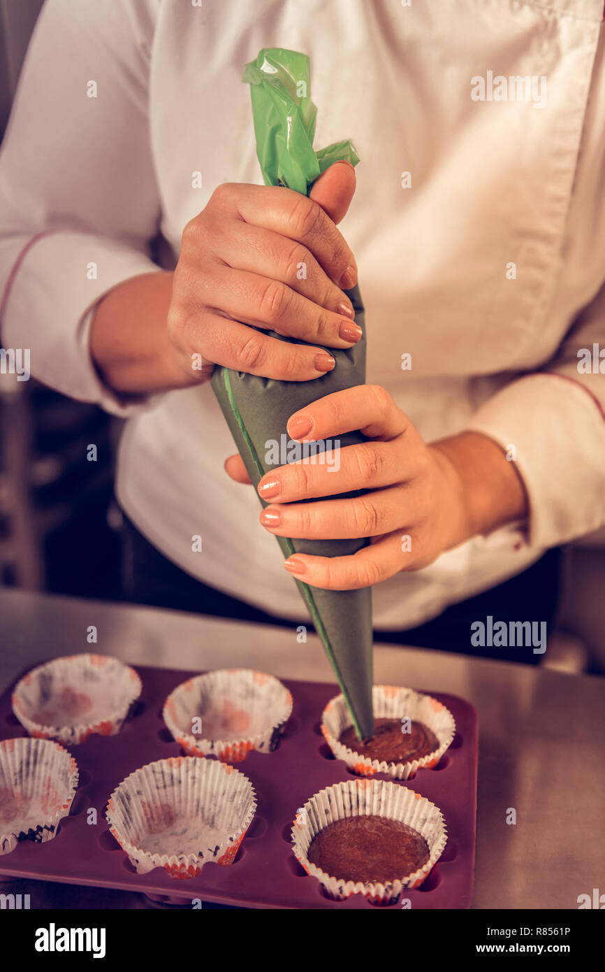 Beste Schokolade Muffins. Professionelle Konditor Holding einen Spritzbeutel  während der Vorbereitung Schokolade Muffins Stockfotografie - Alamy